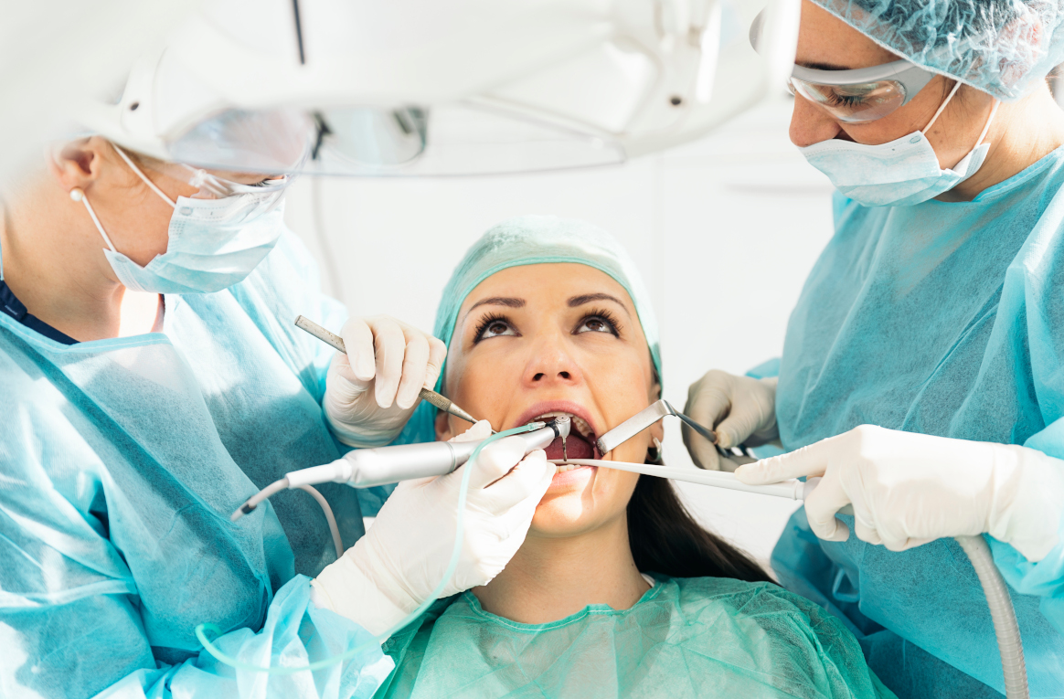 Stomatologist and her assistant treating woman for dental cavity