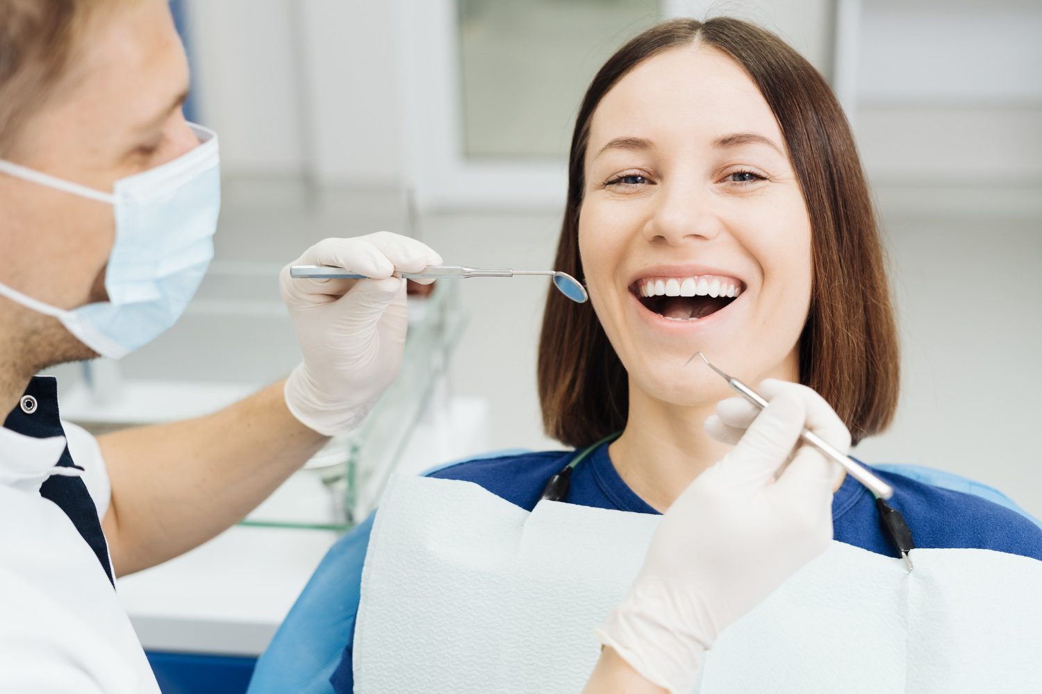 caucasian-male-dentist-examining-young-woman-patient-s-teeth-dental-clinic
