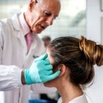 Stomatologist and her assistant treating woman for dental cavity