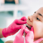 Stomatologist and her assistant treating woman for dental cavity