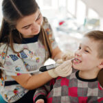 Stomatologist and her assistant treating woman for dental cavity